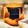 Copper candle holder with a label on a textured fabric background
